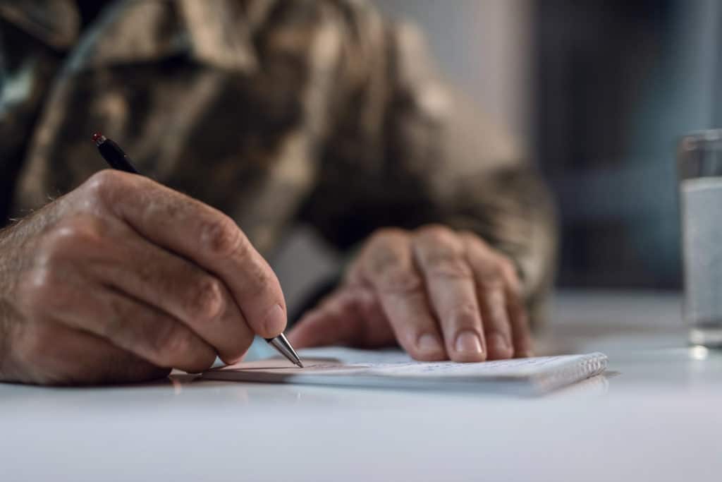 Close up of mature army soldier writing a letter.