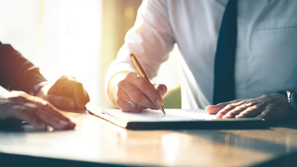 Closeup Businessman signing a contract investment professional document agreement on the table with pen.