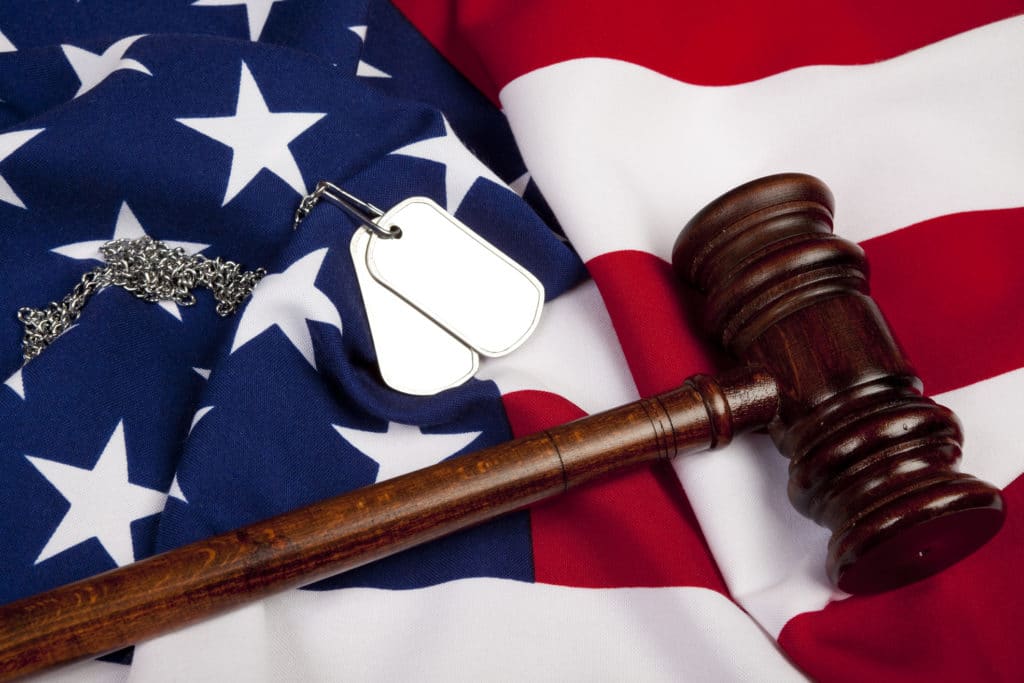 Gavel And Dog Tag On American Flag for "war crimes" concept and veteran rights